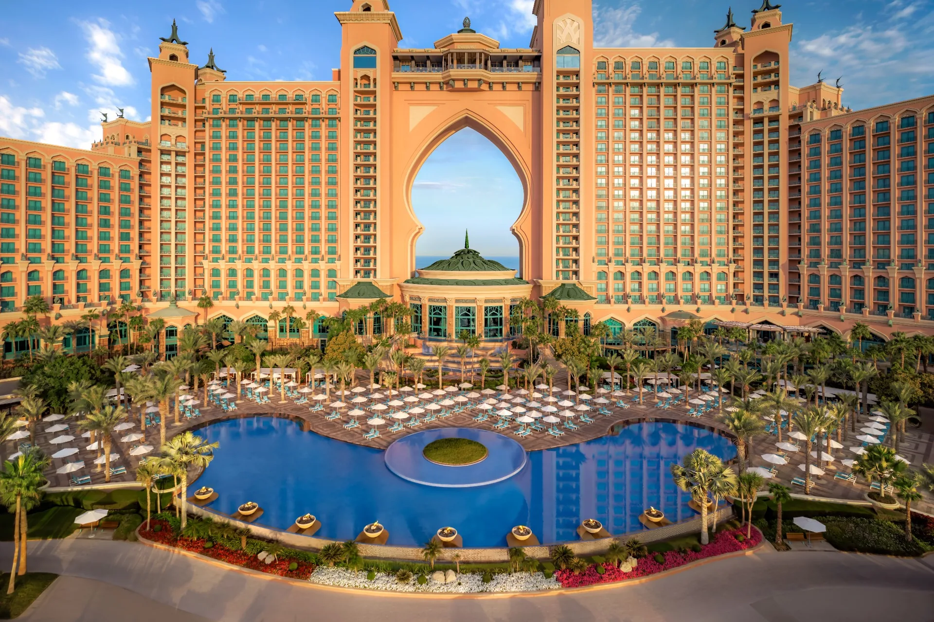 Atlantis, The Palm seen from the front, its arched centrepiece framing the sea above the palm-lined main pool and rows of sun loungers